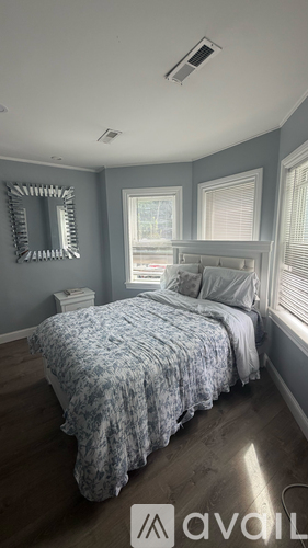 A bedroom with a bed and a mirror on the wall.