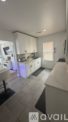 A kitchen with white cabinets and a tiled floor.