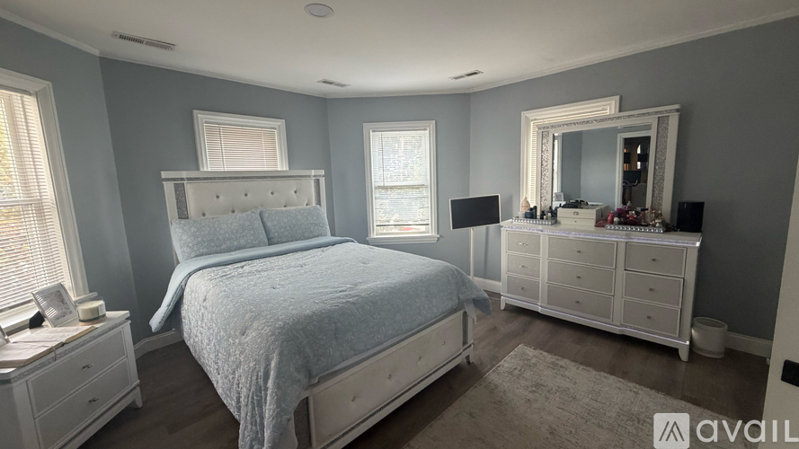 A bedroom with a bed, dresser, and mirror.
