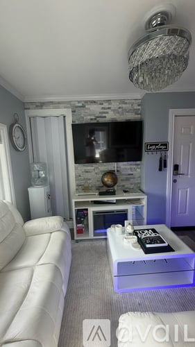 A living room with a white sofa and a glass coffee table.