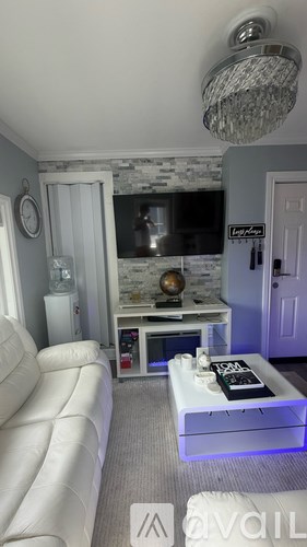 A living room with a white sofa and a glass coffee table.