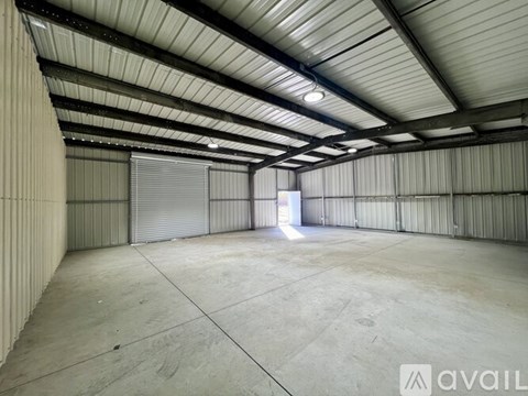 A large, empty warehouse with a concrete floor and a metal roof.