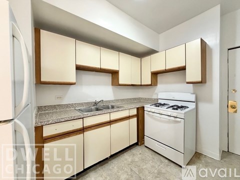 A kitchen with white appliances and wooden cabinets.