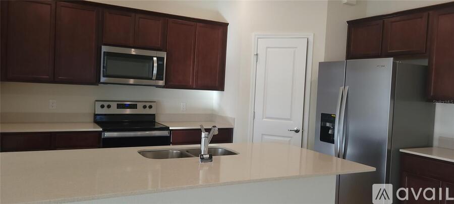 A kitchen with brown cabinets and a stainless steel refrigerator.