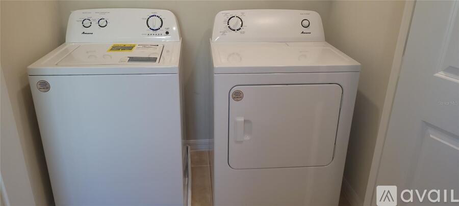 Two white front loading washing machines in a laundry room.