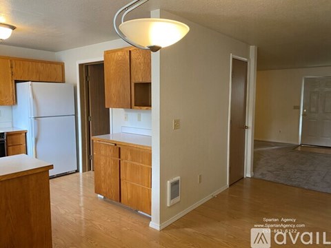 A kitchen with wooden cabinets and a white refrigerator.