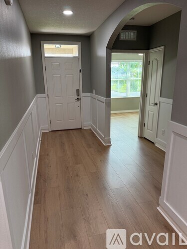 A hallway with wood floors and white trim.