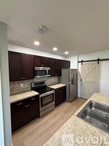 A kitchen with dark brown cabinets and stainless steel appliances.