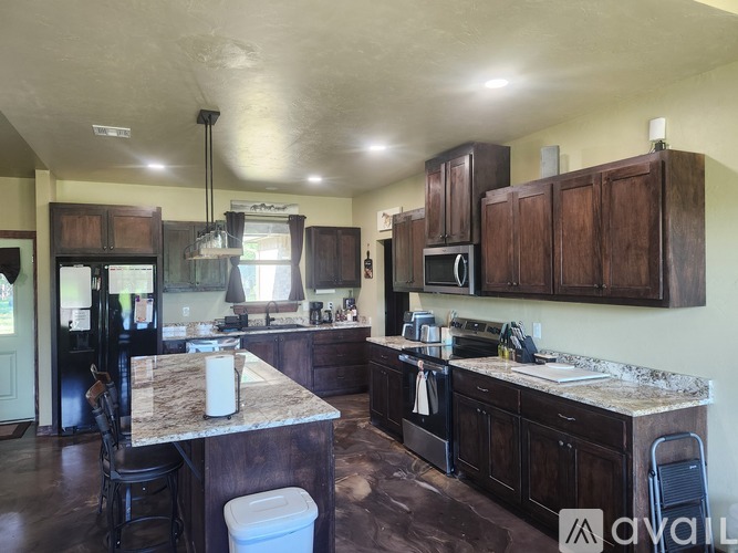 A kitchen with brown cabinets and a granite countertop.