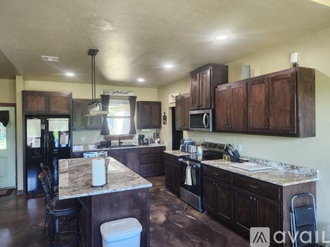 A kitchen with brown cabinets and a granite countertop.