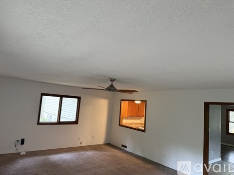 A room with a ceiling fan and a window.