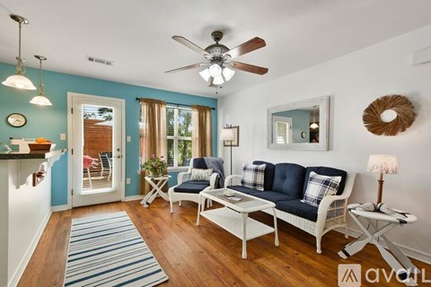 A living room with a white sofa and a ceiling fan.