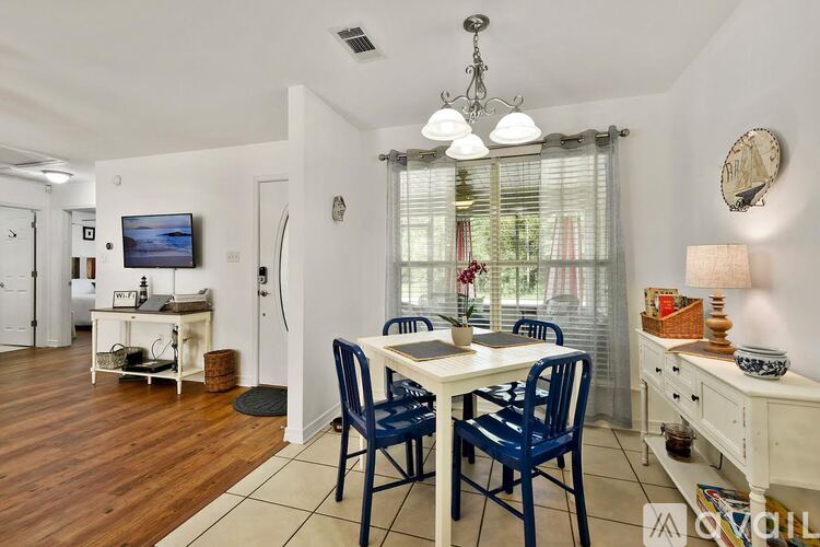 A dining room with a white table and blue chairs.