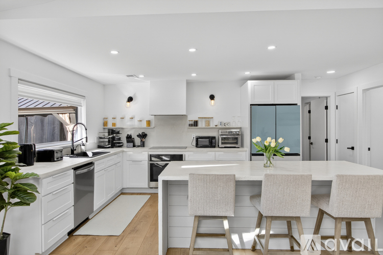 A modern kitchen with white cabinets and a central island.