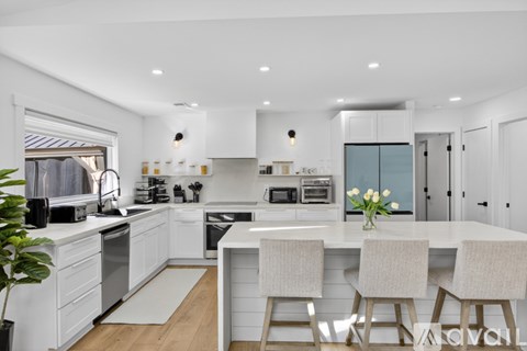 A modern kitchen with white cabinets and a central island.