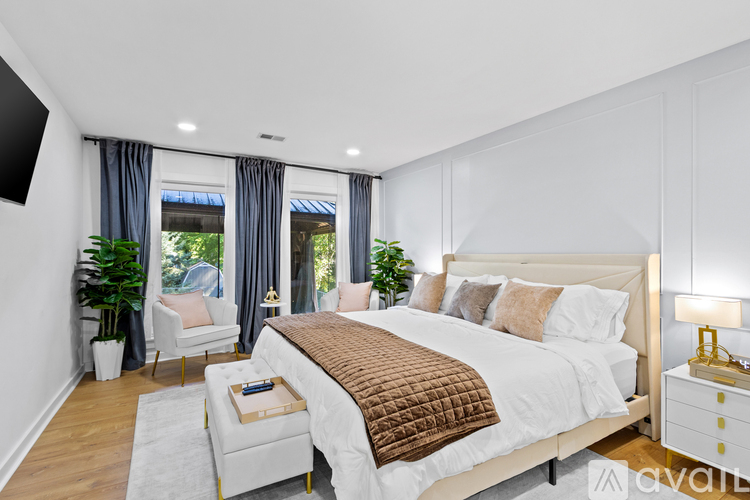 A bedroom with a large bed and a window with curtains.
