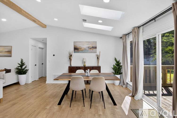 A dining room with a wooden table and chairs.