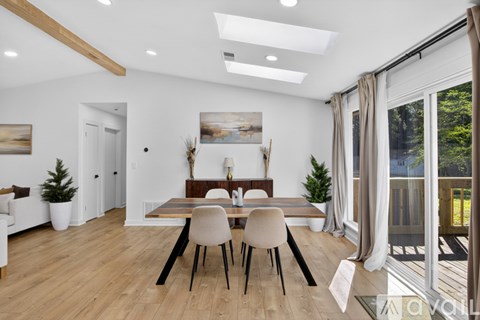 A dining room with a wooden table and chairs.