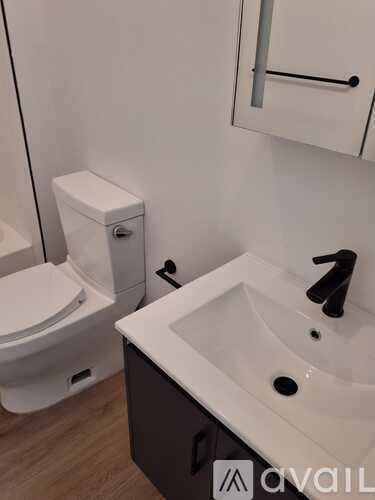 A white toilet sits next to a sink in a bathroom.