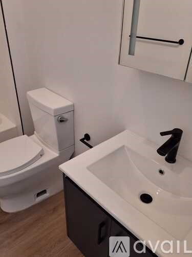 A white toilet sits next to a sink in a bathroom.