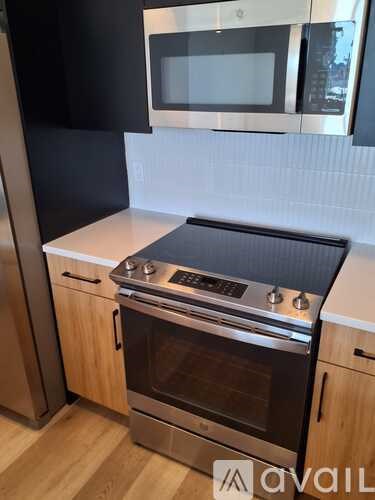 A modern kitchen with a stainless steel oven and microwave above it.