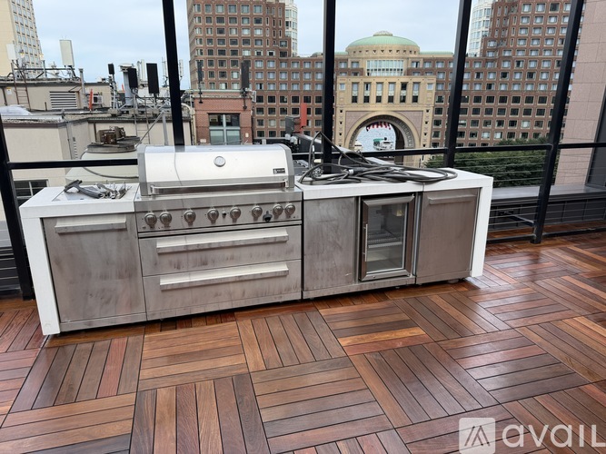A rooftop patio with a grey tiled floor and glass walls.