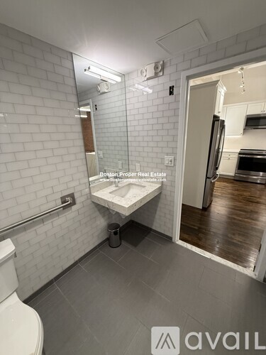 A bathroom with a toilet, sink, and mirror.
