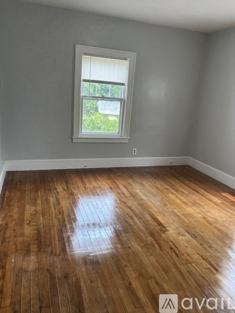 A room with wooden flooring and a window.