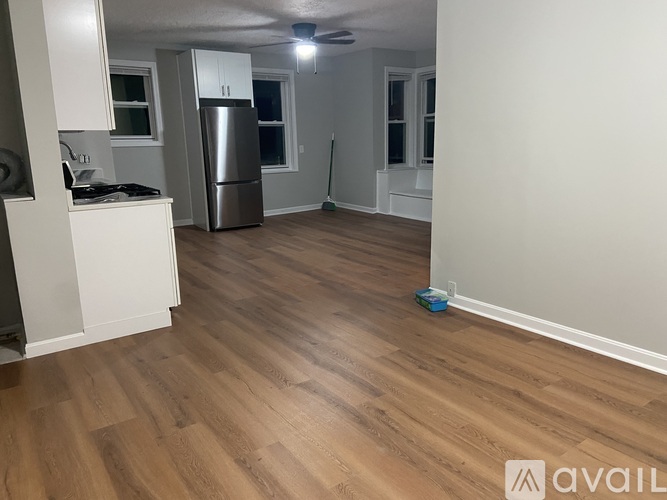 A kitchen with a refrigerator, cabinets, and a countertop.