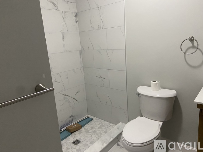 A white toilet in a bathroom with a marble wall.