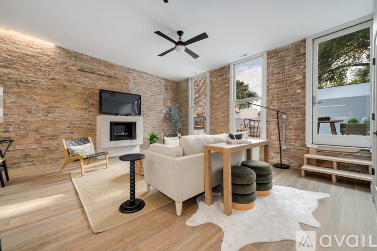 A living room with a white couch, a wooden coffee table, and a brick wall.