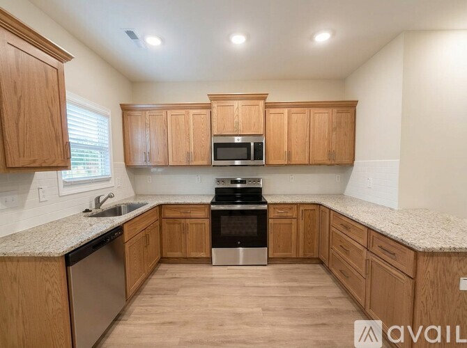 A kitchen with wooden cabinets and a granite countertop.