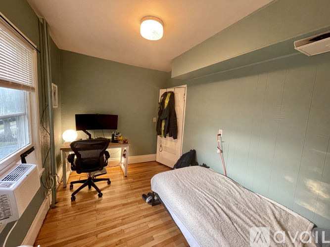A bedroom with a bed, desk, and chair.