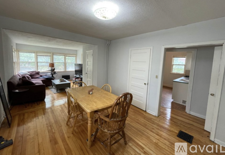 A living room with a brown couch, a wooden table, and a television.