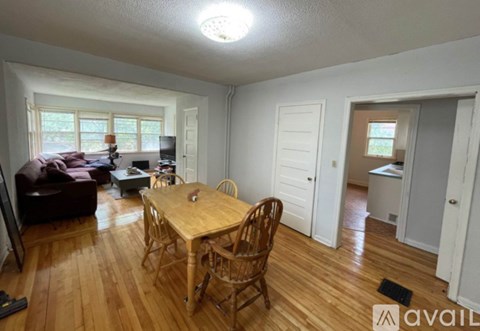 A living room with a brown couch, a wooden table, and a television.
