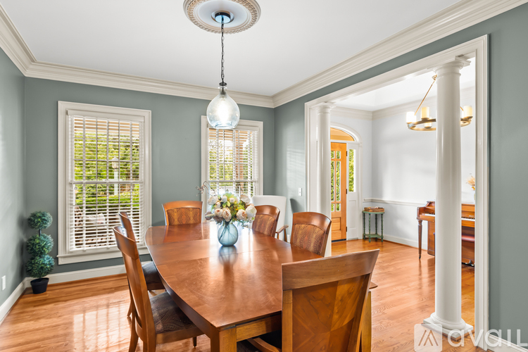 A dining room with a wooden table and chairs.