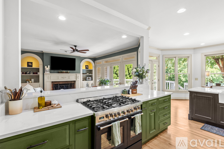 A kitchen with green cabinets and a black stove top.