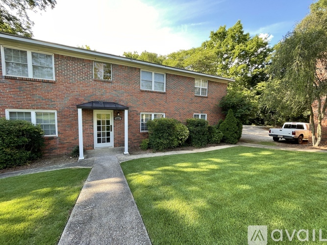 A brick house with a green lawn in front.