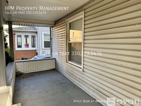 A house with a porch and a sign that says HPM Property Management.
