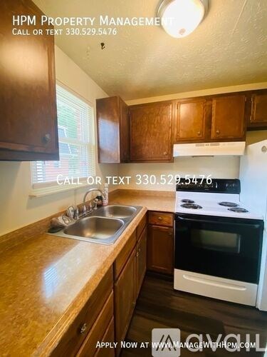 A kitchen with wooden cabinets and a white stove top oven.