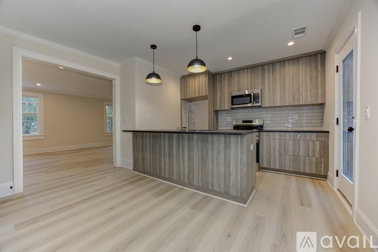 A modern kitchen with wooden cabinets and a central island.