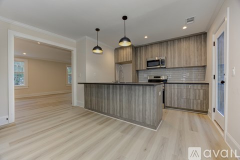 A modern kitchen with wooden cabinets and a central island.