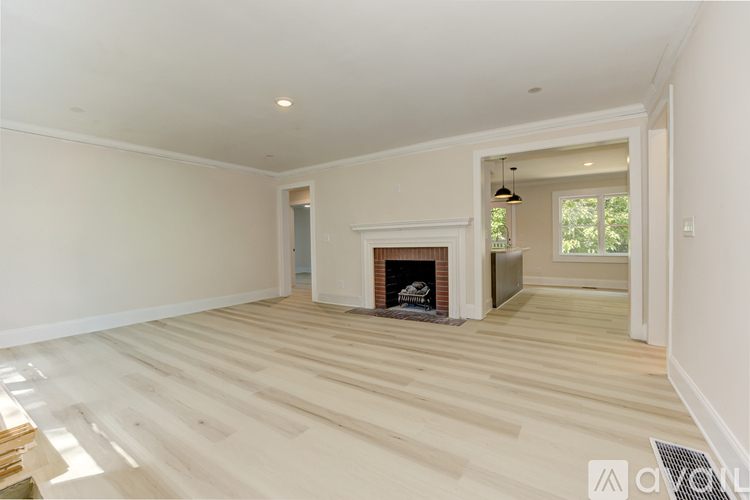 A living room with a fireplace and a doorway leading to another room.