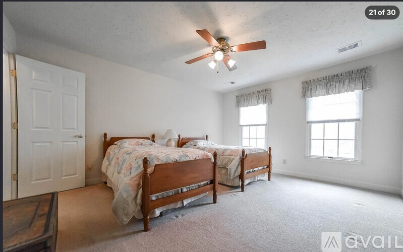 A bedroom with a bed, dresser, and window.