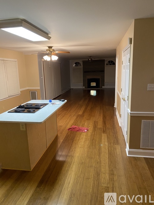 A kitchen with wooden floors and a stove top oven.