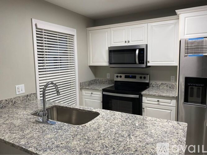 A kitchen with granite countertops and stainless steel appliances.