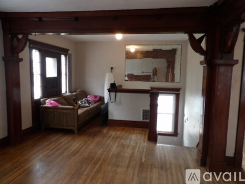 A living room with a couch and a wooden floor.