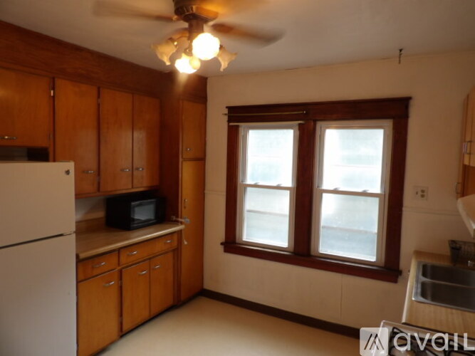 A kitchen with wooden cabinets and a white refrigerator.