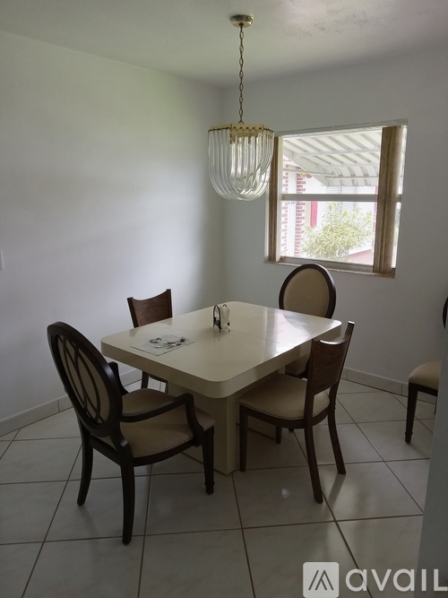A dining room with a table and chairs.