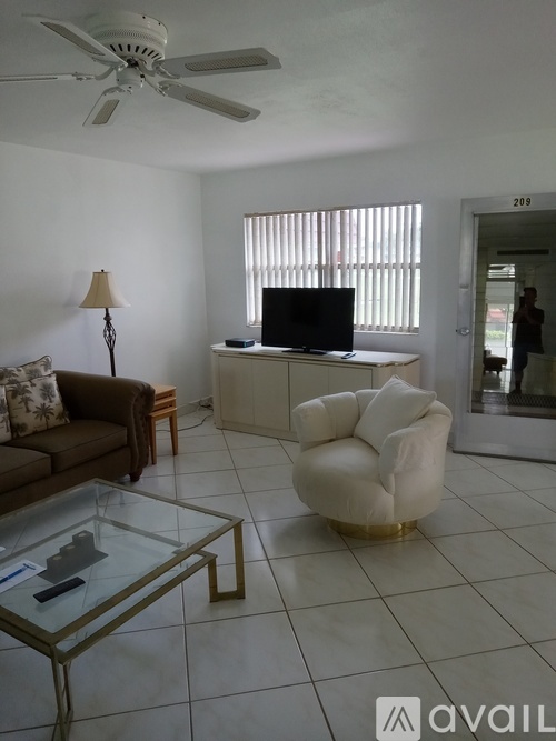 A living room with a couch, chair, and television.